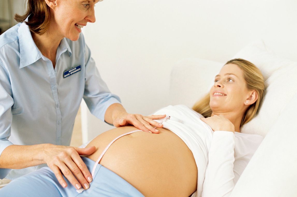 ^BMODEL RELEASED^b. ^BObstetric examination.^b Midwife measuring a pregnant woman's abdomen. This is done in order to estimate the growth and development of the foetus.